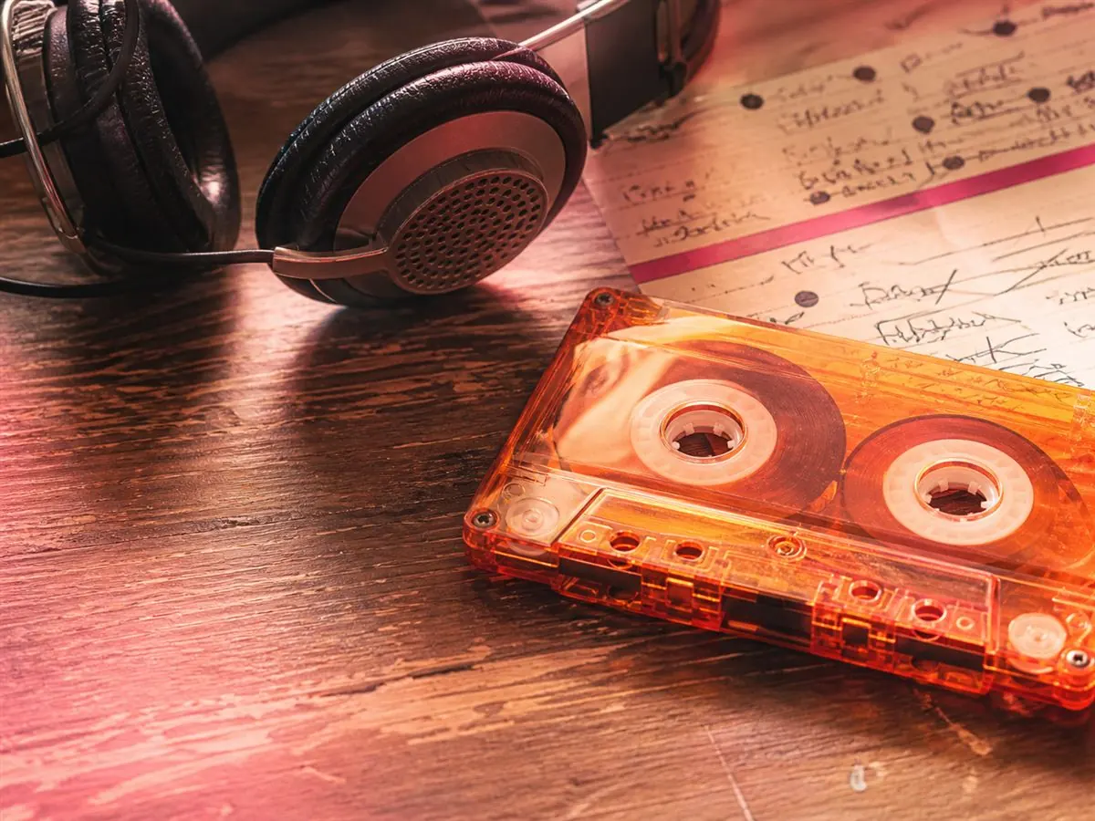 Cassette audio orange et casque sur une table