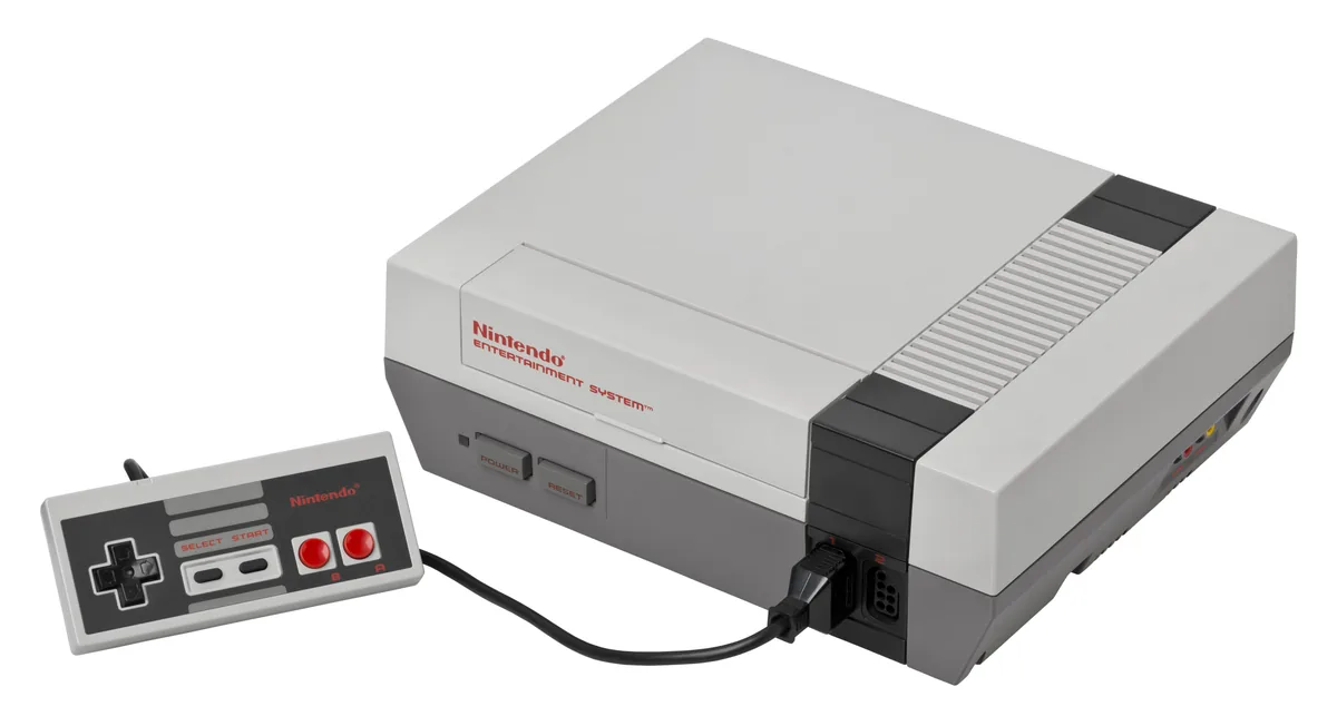 Console NES à chargement frontal accompagnée de sa manette rectangulaire